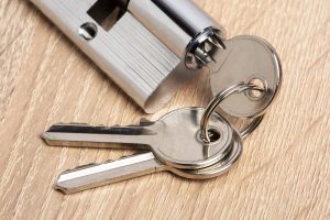 Door lock on wooden background. Key cylinder with keys